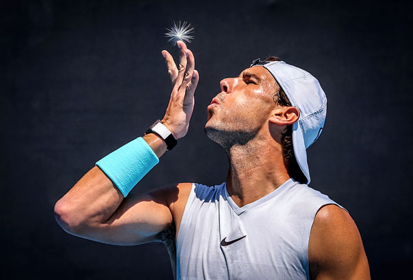 Rafael Nadal blows a dandelion from his finger