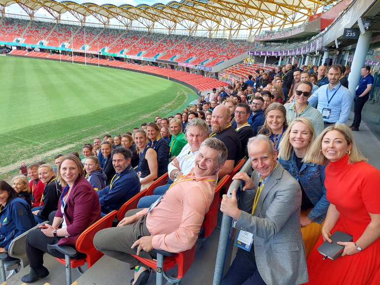 Support performance practitioners gather for group photo on stadium seats