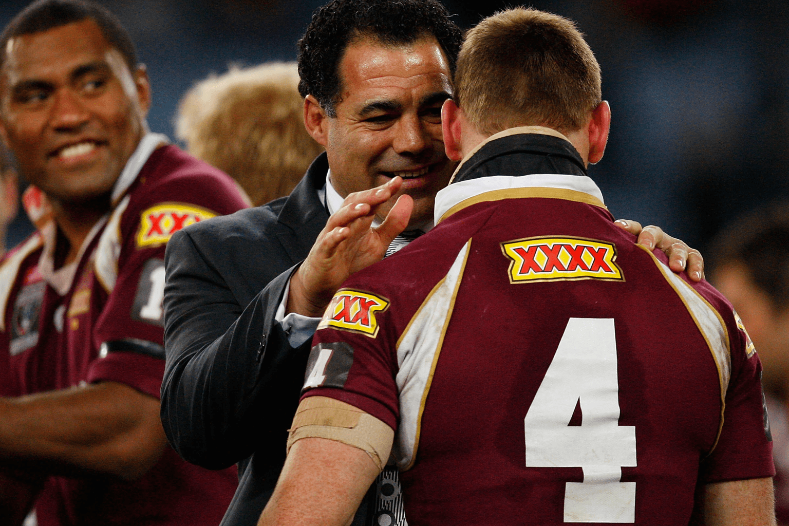 Queensland rugby league coach Mal Meninga congratulates a player wearing the number 4 jersey after a match.