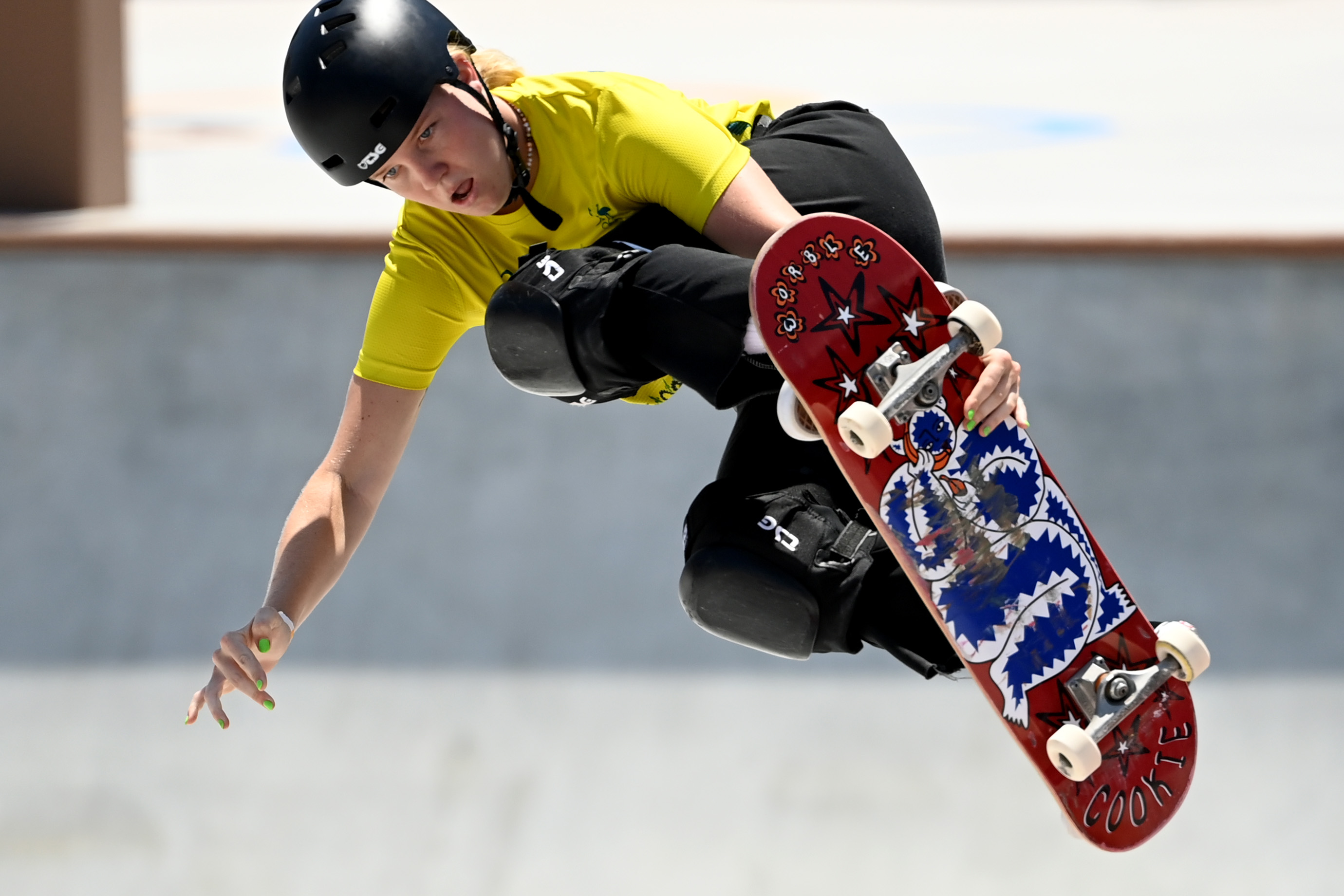 Skateboarder jumps in the air holding their skateboard