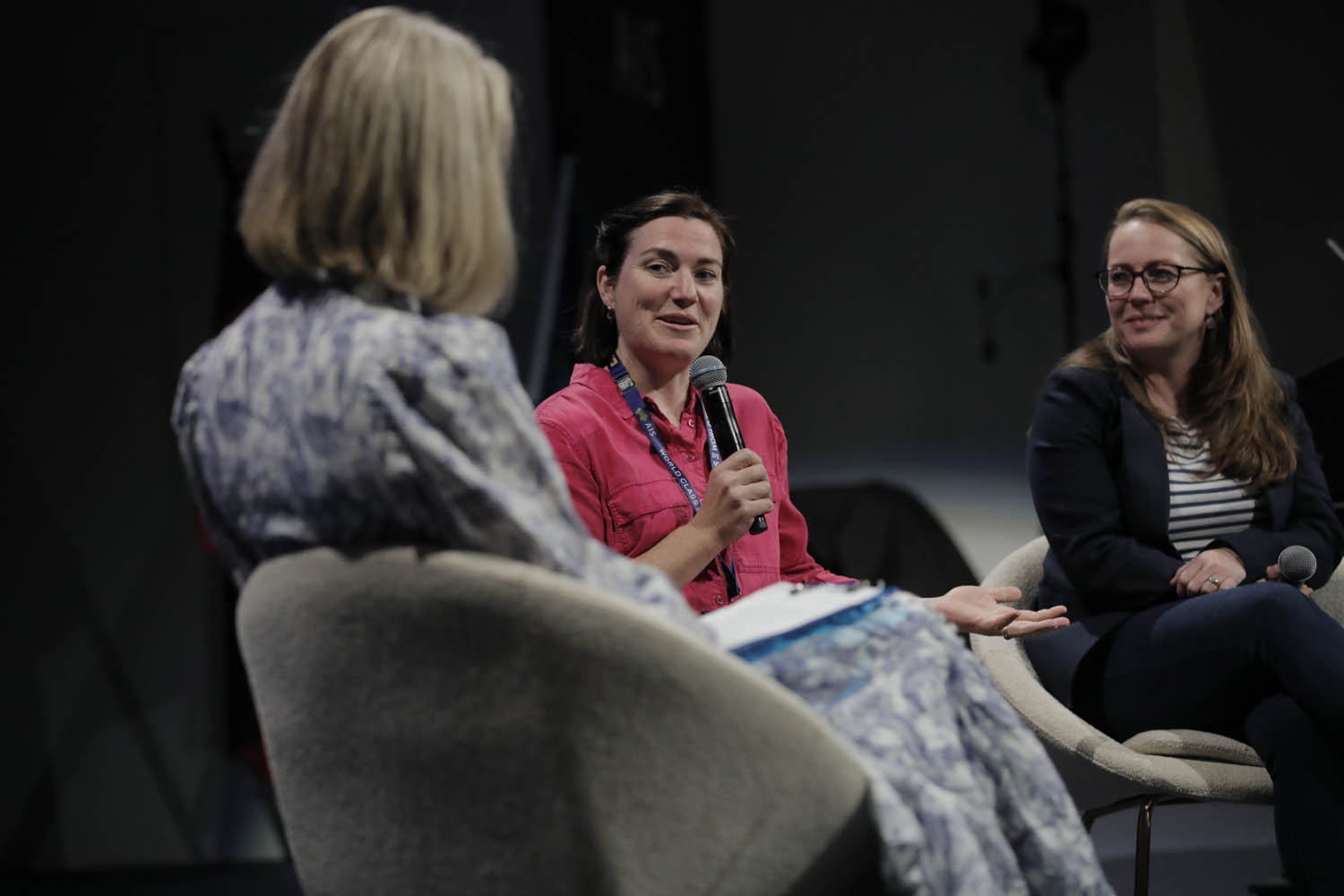 three women sitting together on stage