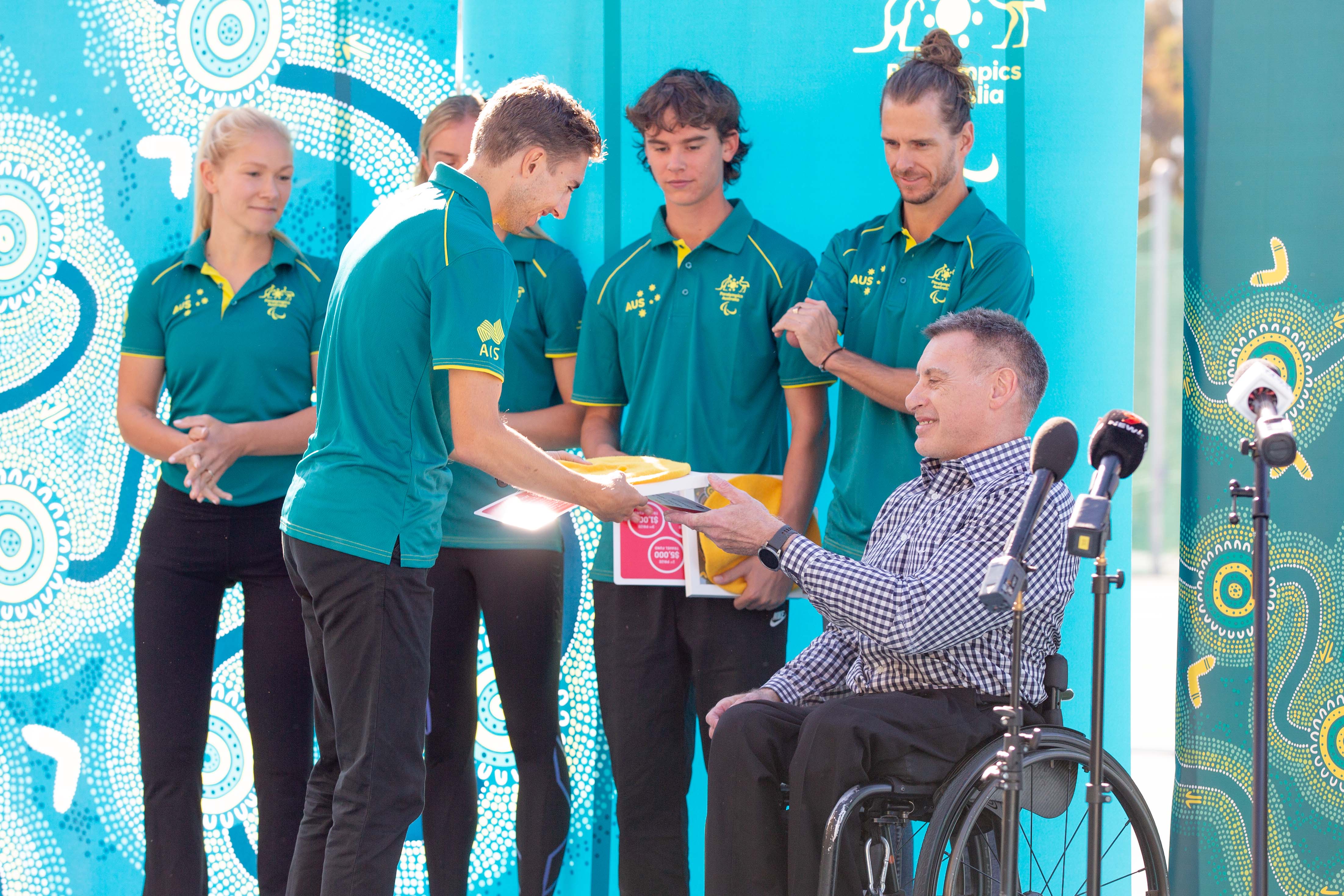 Reece Langdon receives his ticket to Paris from Paralympian Richard Nicholson.