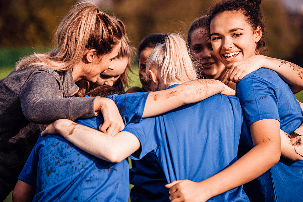 Teenage girls huddle during a sporting match