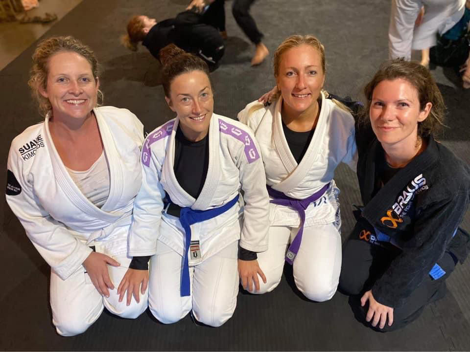 Four women in Jiu Jitsu Gi kneeling, with Tarah Rocha de Oliveira second from right.