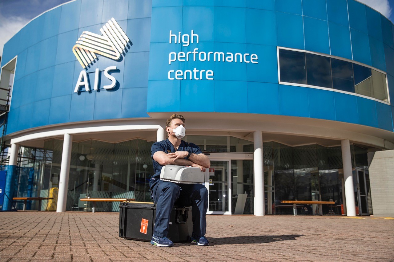 AIS Sports Scientist sits outside the AIS High Performance Centre in Canberra
