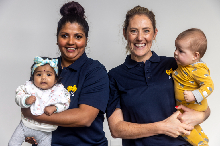 Two coaches holding their babies