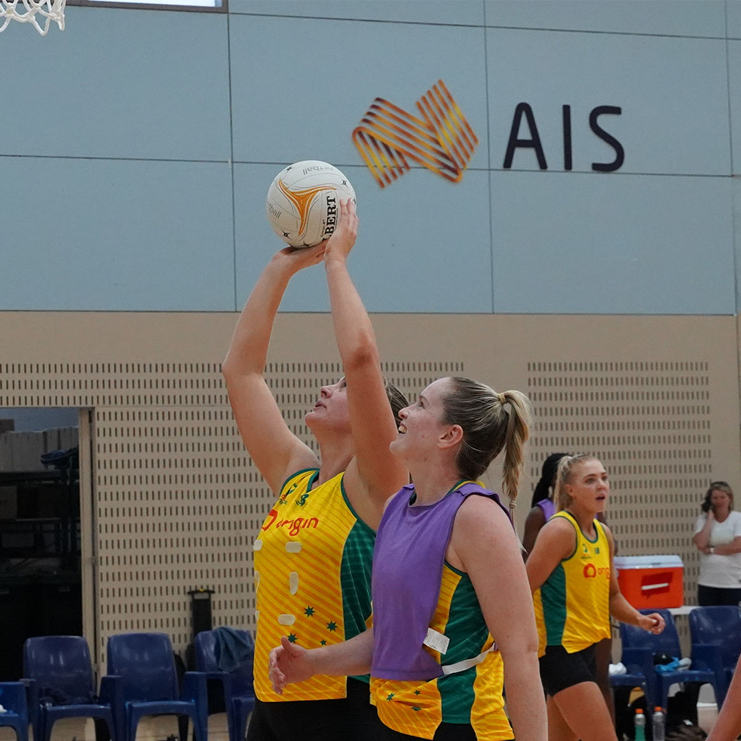 A woman shoots a white netball 