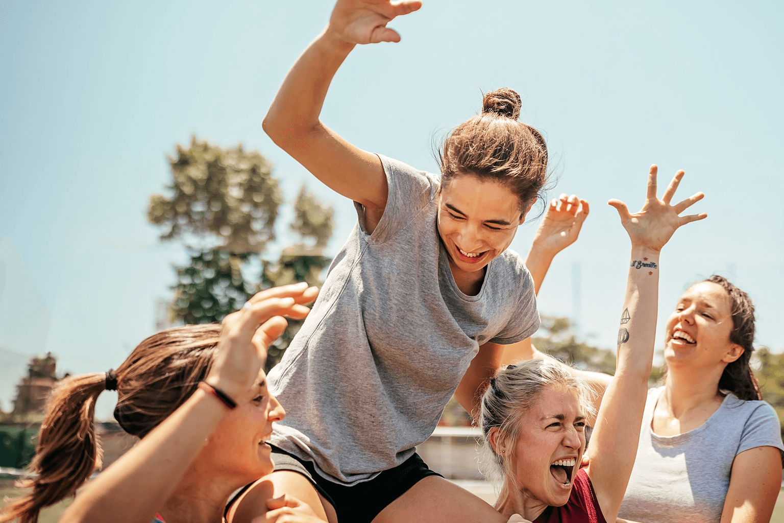 Teammates lift up a young woman in celebration