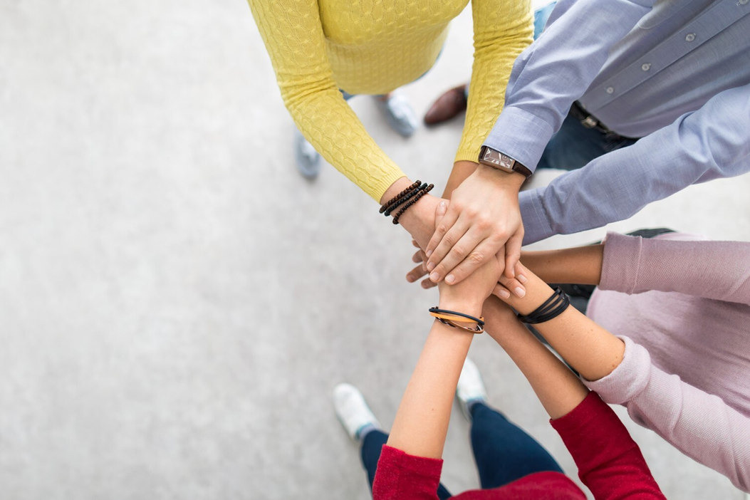 People putting hands on top of each other.