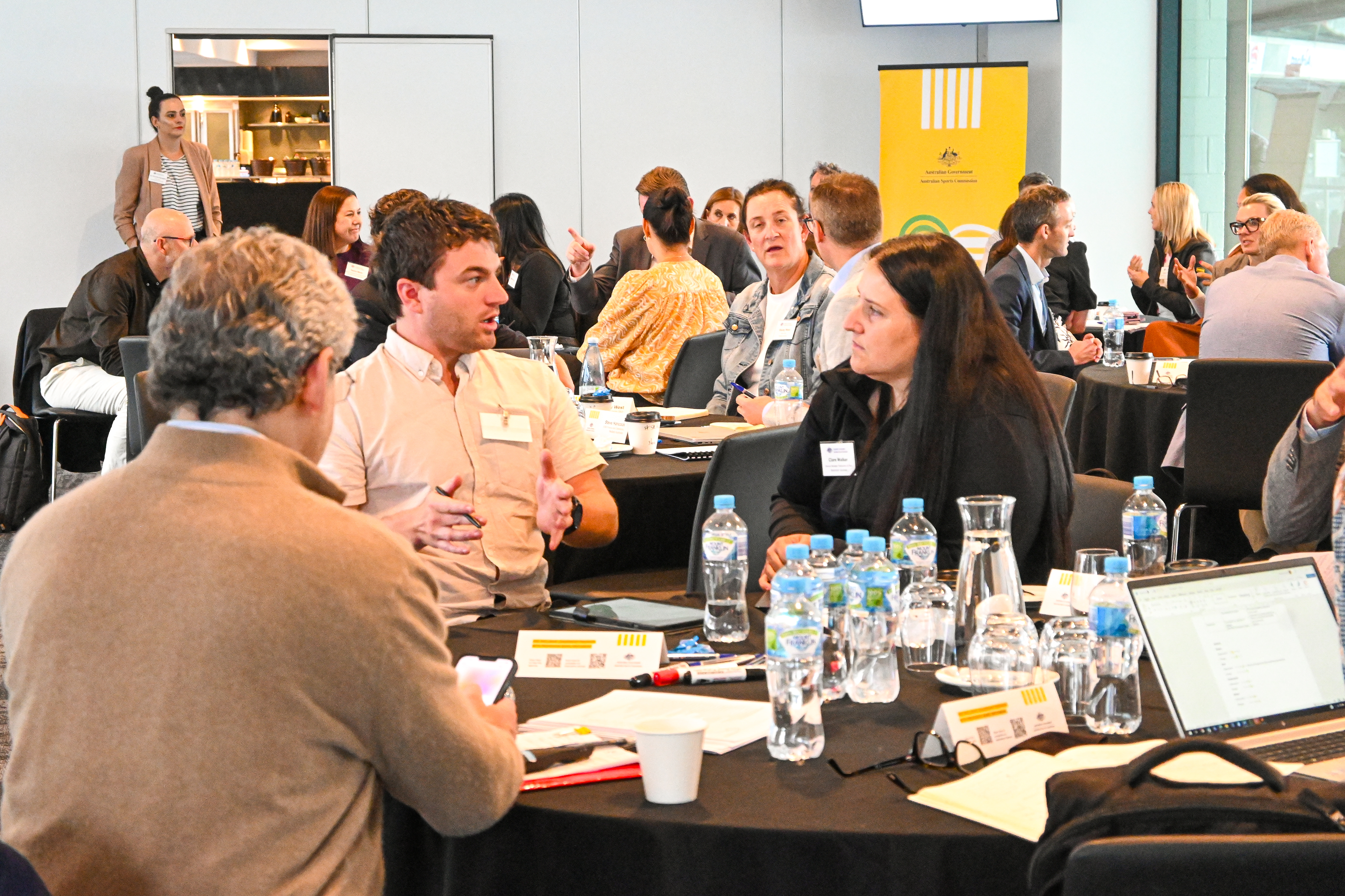 A photo of attendees sitting around tables having a discussion