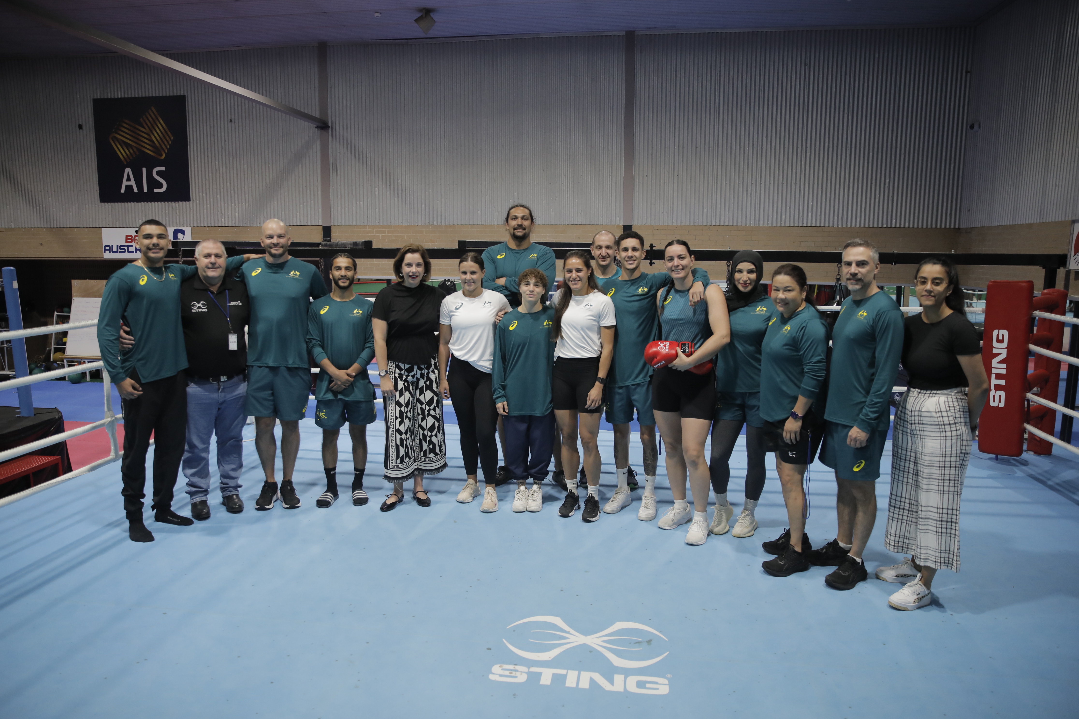 Minister and boxers stand in boxing ring at AIS.