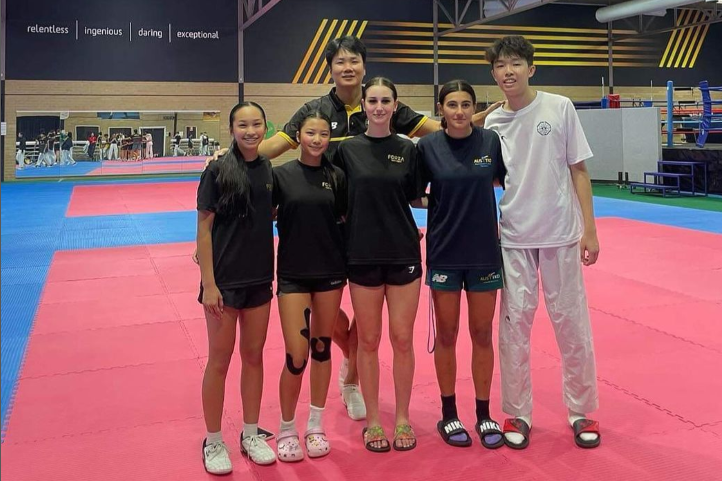 Taekwondo athletes stand in AIS Combat Centre.