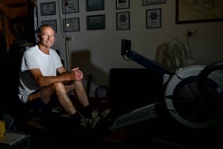 Image of Chris Symons sitting on a rowing machine.