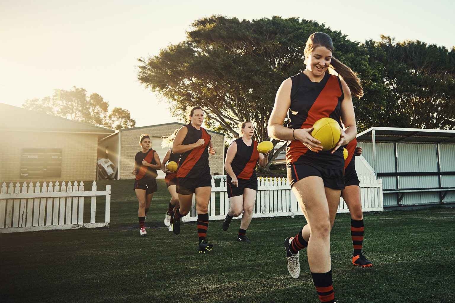 Women run onto a field ready to play football