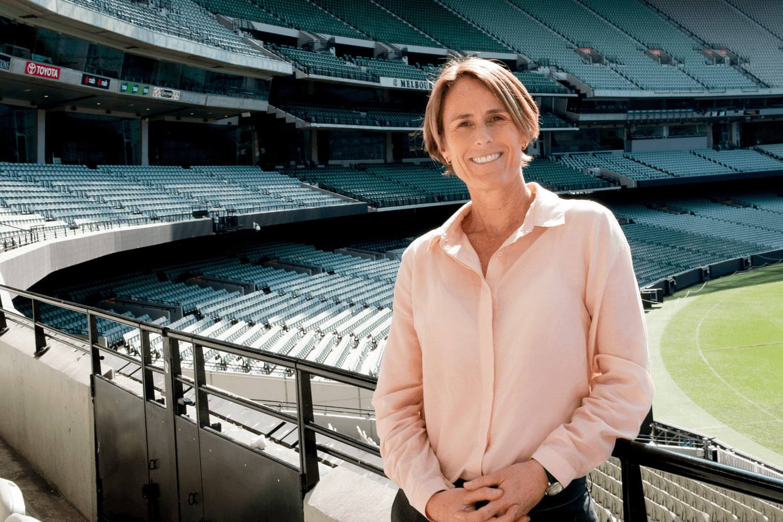 Belinda Clark in the stands beside a cricket oval