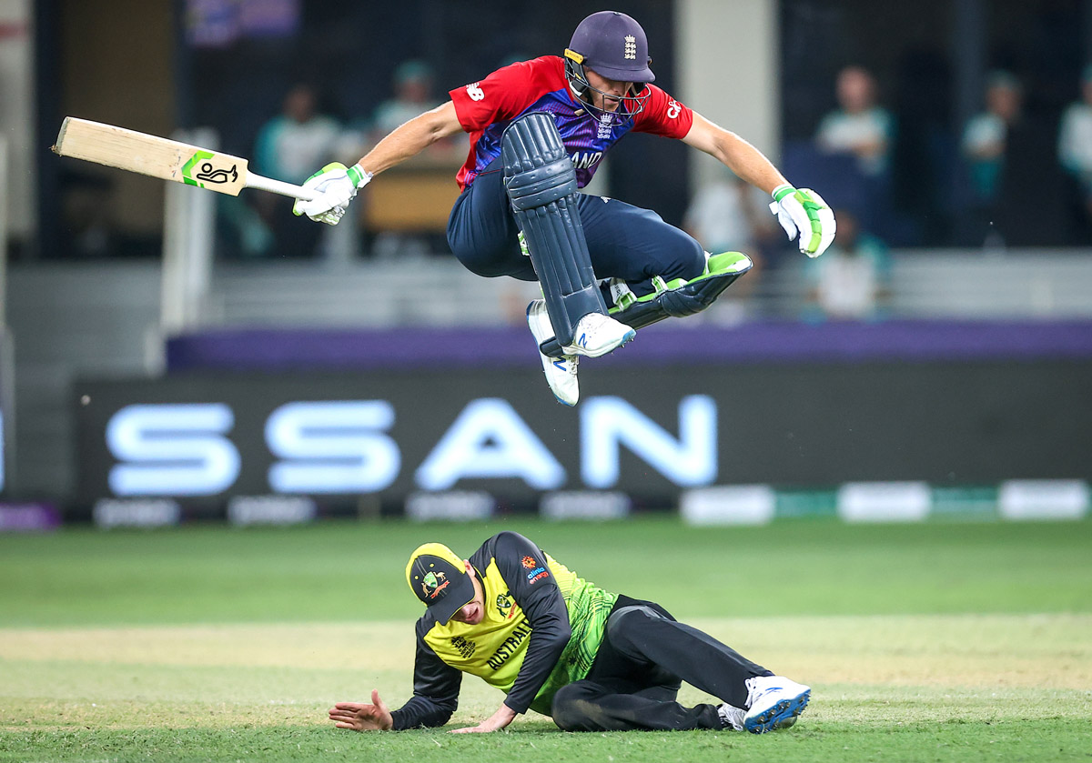 England batsman Jos Buttler jumps over Australian fielder Steve Smith who is lying on the ground during the ICC Men's T20 World Cup cricket match