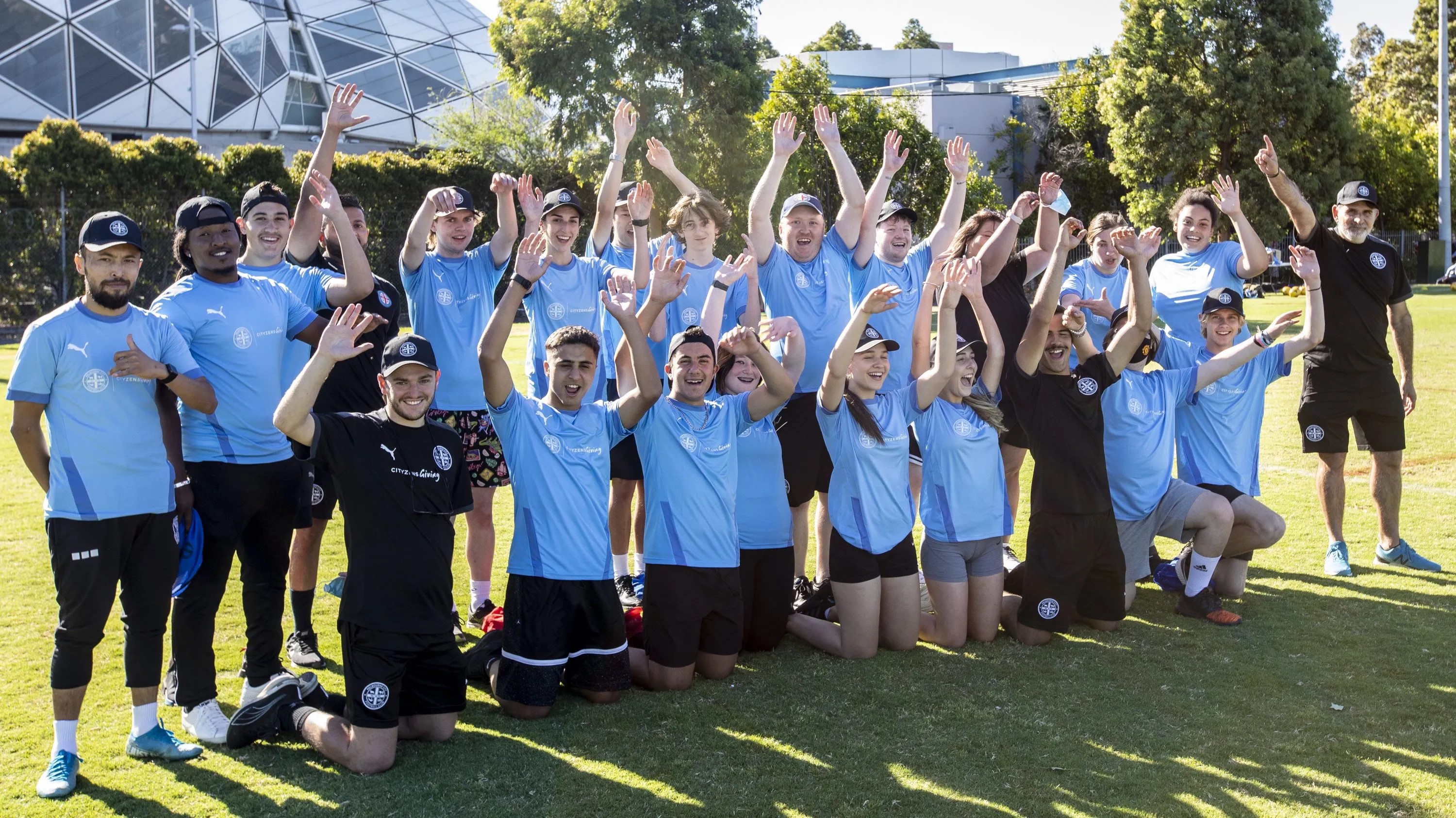 Melbourne City Volunteers with hands in the air