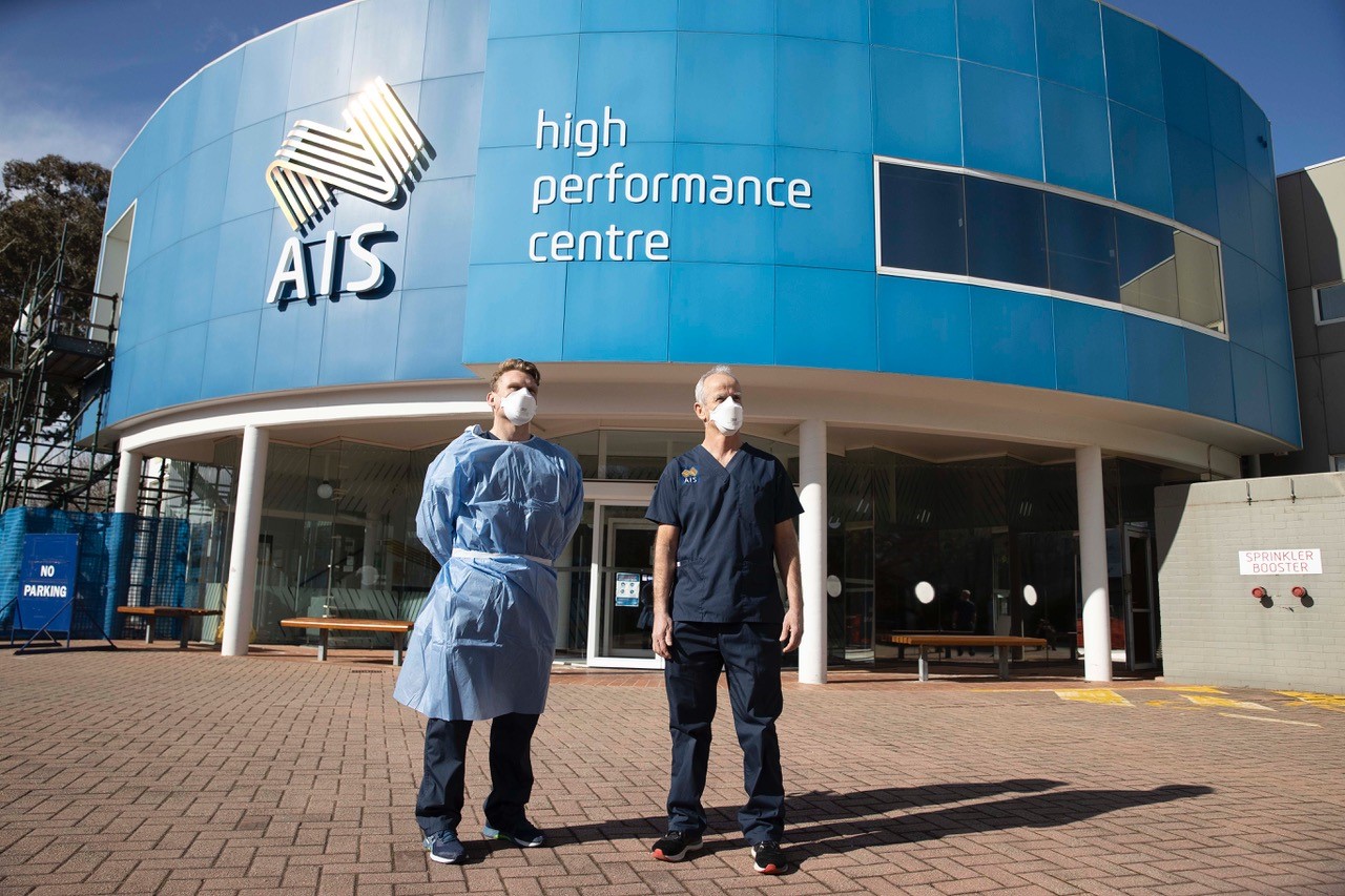 AIS Chief Medical Officer Dr Hughes and AIS PhD Scholar Dr Mat Mooney stand outside the AIS. 