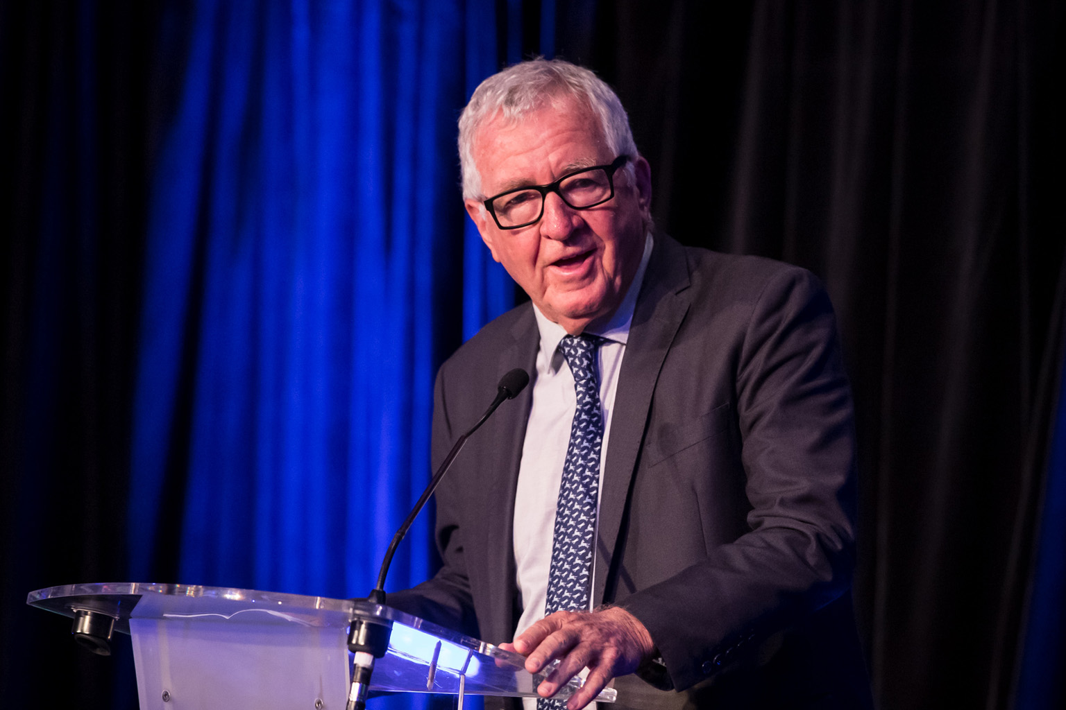 Mike Sheahan standing behind a lecturn