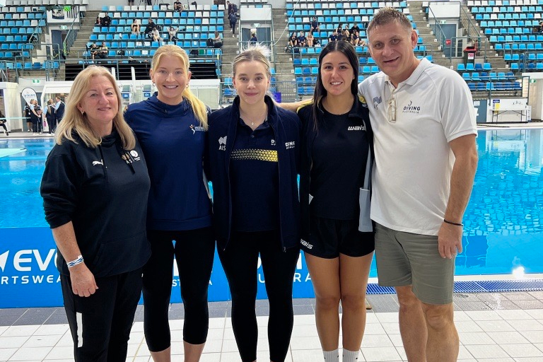 Coaches standing in front of pool